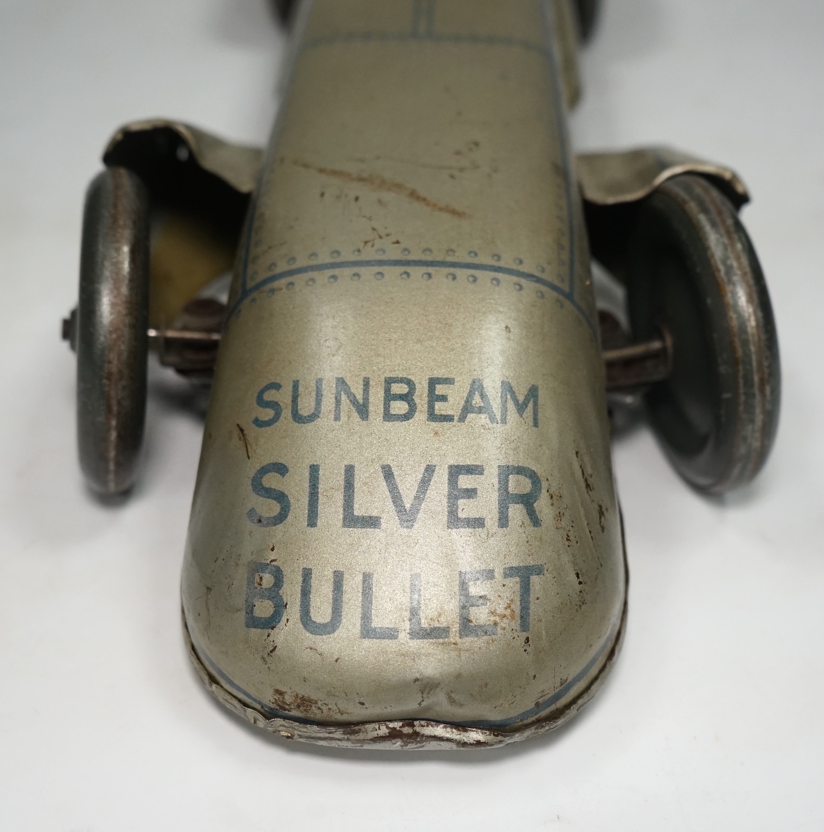 A 1930s Gunthermann (Germany) clockwork tinplate Sunbeam Silver Bullet world record car, with blue printed panel and rivet detail, driver, and Union flags to tail fins, stamped with ‘Foreign’ to underside, 56cm long. Con